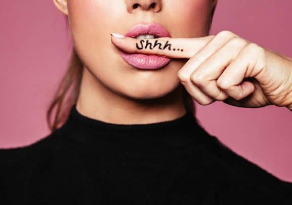 Frau mit Finger vor dem Mund