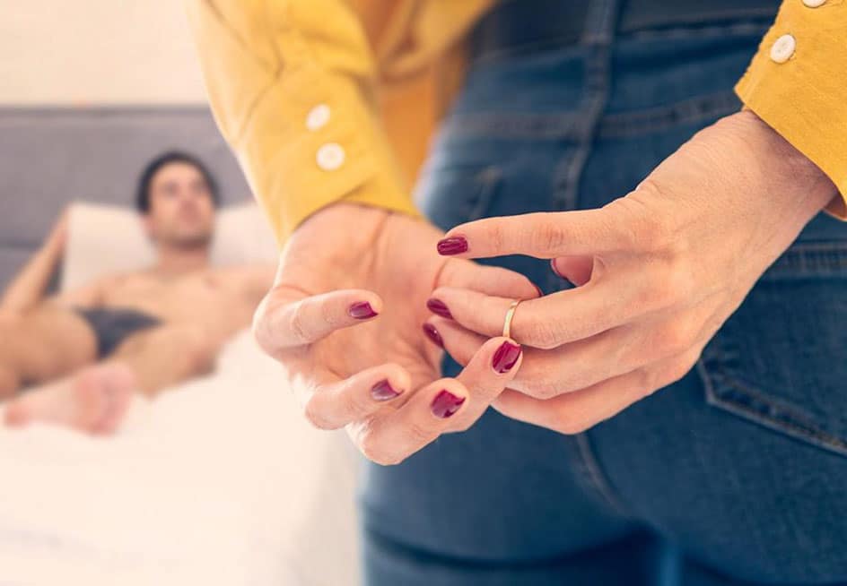 Frau zieht Ehering vom Finger